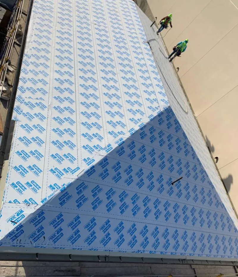 Professional roofers installing underlayment on a metal roof in Rocky Hill